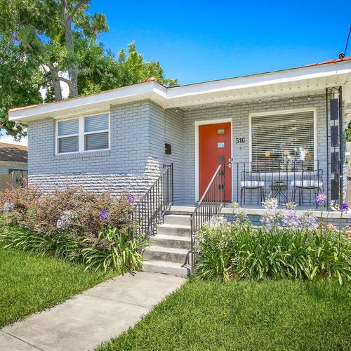 Step into New Orleans charm with this inviting home featuring a vibrant red door and beautifully manicured garden. The welcoming front porch is the perfect spot to sip your morning coffee and enjoy the lively neighborhood atmosphere