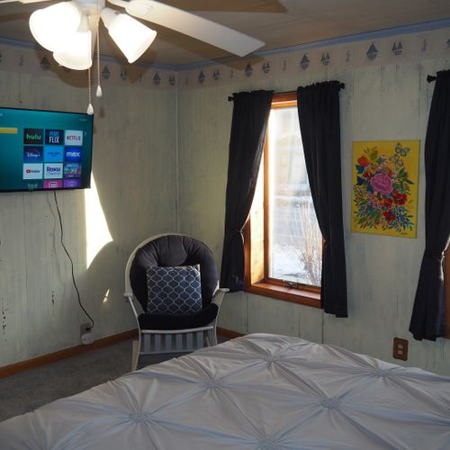 Bedroom #1 (main floor):  features a queen-size bed, private television, dresser, ceiling fan, closet, and en suite private bathroom.