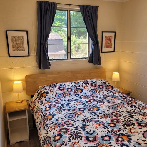 Bedroom #1:  features a queen-size bed, nightstands, lamps, mirror, and closet.