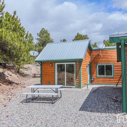 The exterior of our trout cabin with picnic seating just outside your door.
