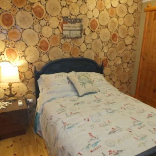 Bedroom #2:  bedroom #2 (on the left at the end of the hallway) is at the front of the house. It features a beautiful nautical theme, a full-size bed, and its own en suite (attached) bathroom. (the door to the bathroom is visible in the photo. )