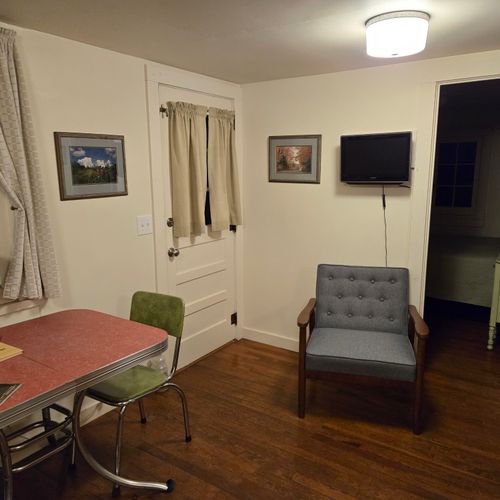Living room:  the cabin has a cute little living room with a loveseat, dining table, and streaming television.