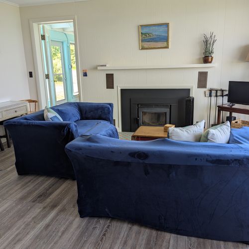 LIVING ROOM:  The home has a comfy living room that includes a wood fireplace and a television.