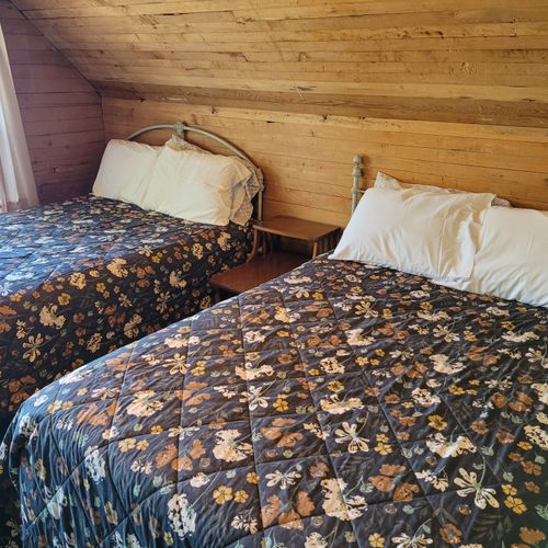 BEDROOM #4 (UPPER FLOOR):  Features two full-size beds, a dresser, closet, and a great view of Crystal Lake!