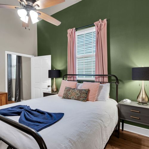 Restful bedroom w/ green accent walls & soft bedding for a good night's sleep.