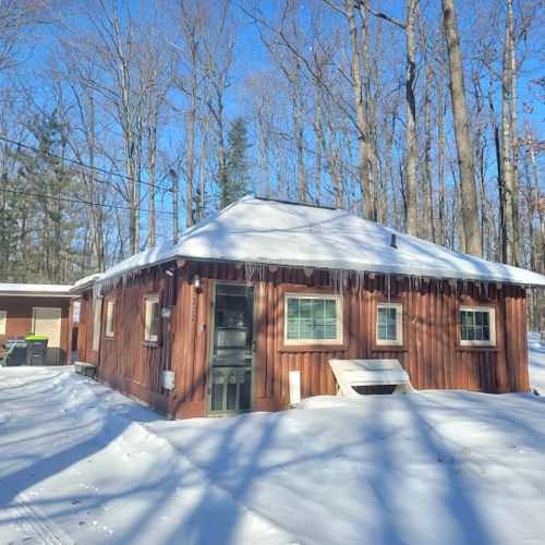 Overall:  a broader view of the front of the cabin in winter.