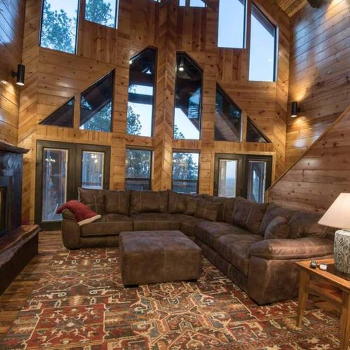 The main living room has an oversized sectional around the tv and fireplace.