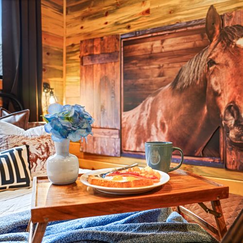 Soft linens, warm woods, and striking horse art create a cozy, unforgettable escape.