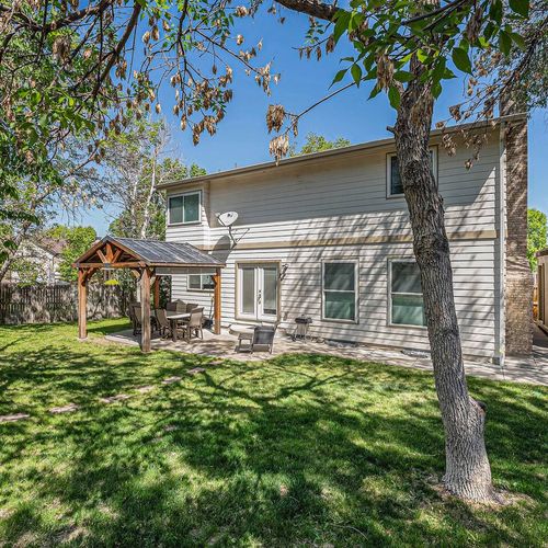Lush backyard escape with covered deck dining, perfect for laid-back afternoons.