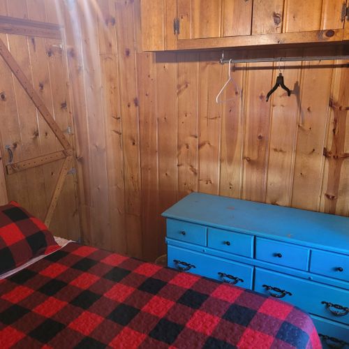 Bedroom #1:  features a queen-size bed, nightstand, lamp, mirror, dresser, and clothes rack.