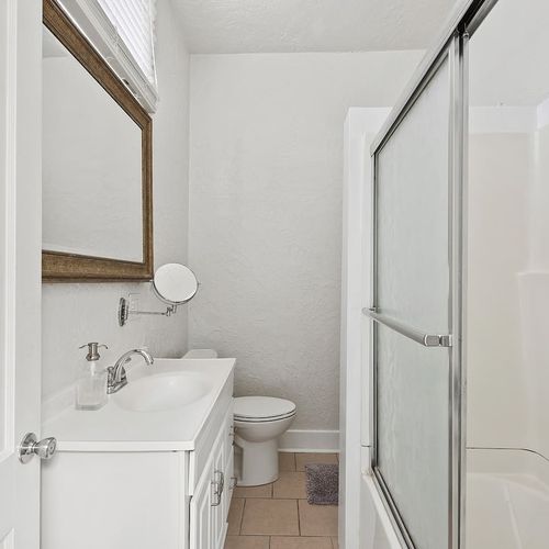 Bright and modern bathroom with a walk-in shower, offering both style and convenience for your stay.