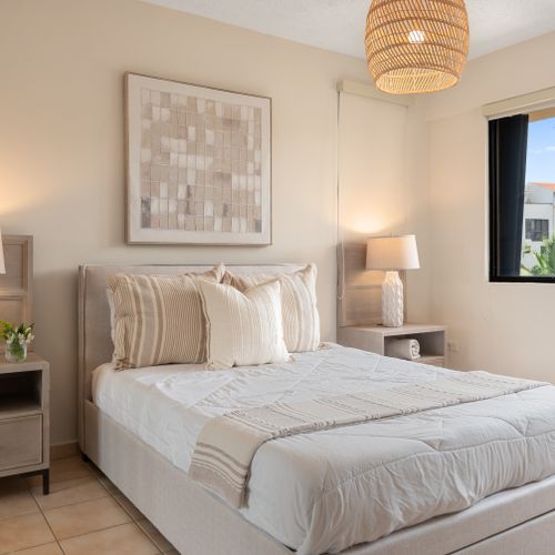 Relax in the spacious master bedroom featuring a plush Queen bed and direct access to your private balcony.