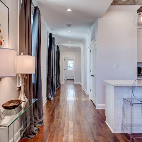 Sun-lit hallway leading to the bedrooms — clean lines & warm wood floors.