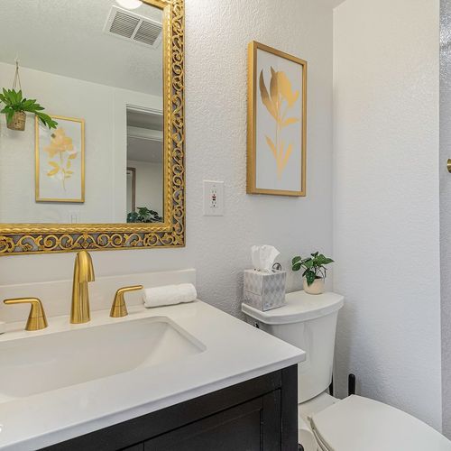 Experience the luxurious comforts of this meticulously designed bathroom featuring a euro-style glass shower with beautiful brass accents.