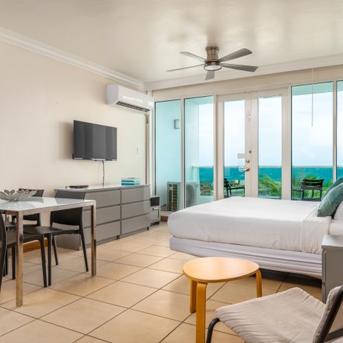 Perfect for extended stays! This studio features a large bed, dedicated dining space, and a well-equipped kitchen area.
