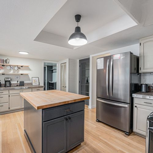 The kitchen centerpiece is a substantial butcher block island, ideal for meal preparation.