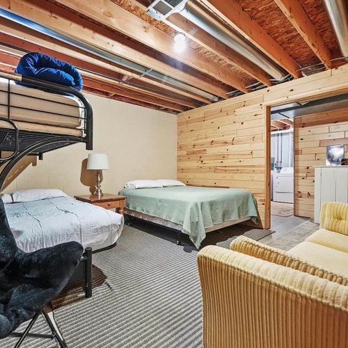 Lower level:  partially-finished basement area includes a queen-size bed, twin-on-full bunkbed, sofa, and dresser.