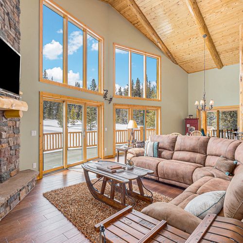 Captivating floor-to-ceiling windows illuminate the open-concept dining, kitchen bar, and living area, creating a spacious and luminous ambiance.