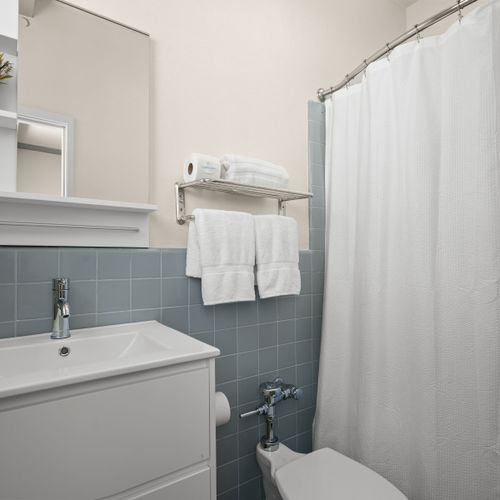 Refresh and rejuvenate in our immaculate bathroom, boasting fresh towels, essential toiletries, and a clean, spacious vanity for your convenience.
