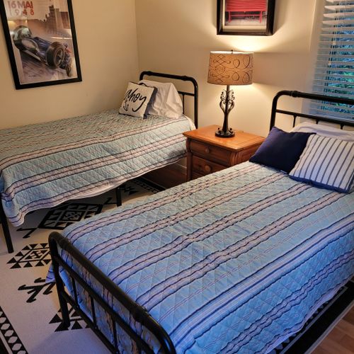 Bedroom #3 (first floor):  features two twin beds, dresser, closet, nightstand, and lamps.