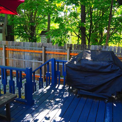 Exterior:  the fully fenced-in backyard with newly expanded deck, new hot tub, bonfire ring, propane grill, and picnic table with umbrella.