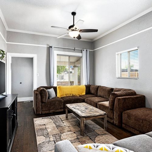 - relax on the oversized sectional with warm tones and stylish modern decor
- ceiling fan and large window keep the room comfortable all day
- perfect for gathering around the tv or curling up with a good book