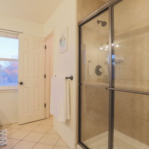 The master ensuite bathroom features a walk-in shower enclosed with glass doors and rain shower.