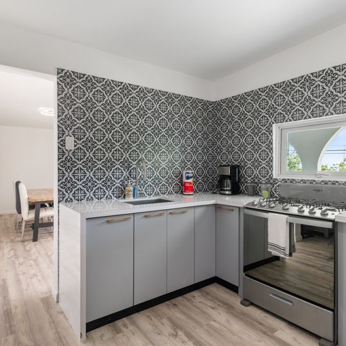 A modern kitchen with a stylish backsplash and ample room for food prep.