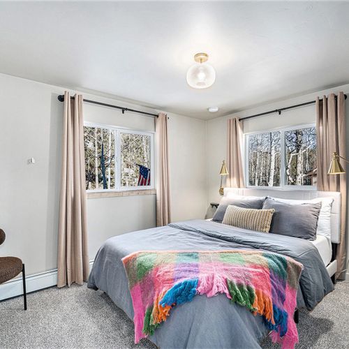 Relax in comfort in this serene queen bedroom, featuring luxurious linens for a restful night's sleep.