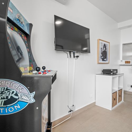 "Step into our playful corner featuring a Champion Edition Street Fighter arcade machine—perfect for game enthusiasts looking for a challenge during their stay.