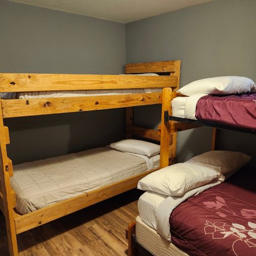 Main room:  the main room, which features 6 beds (5 twins and 1 double), a small dining table, and a small sink / kitchenette.