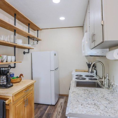 - efficient kitchenette equipped with microwave, electric stove, and full fridge
- rustic industrial shelves keep essentials within easy reach for your morning brew
- thoughtful touches like a coffee station and wood style flooring add cozy flair