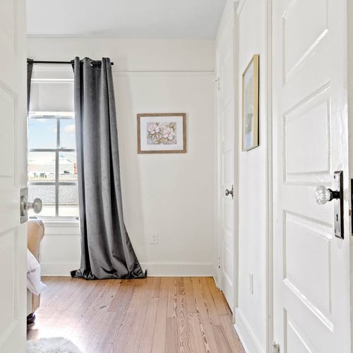 Bright bedroom w/ curtains & natural light.
