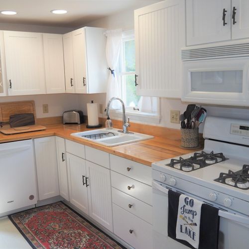 Kitchen:  looking into the large and modern kitchen, which includes all appliances (including a dishwasher and a gas range), lots of cupboard and counter space, a "coffee cabinet", and a good supply of cooking and dining utensils.