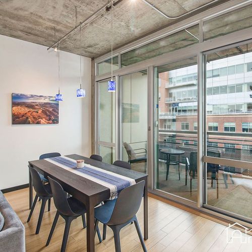 - dine with a view in this bright space featuring floor to ceiling glass doors and city sights
- blue pendant lights add a pop of color to the clean contemporary setup
- ideal for group meals, morning coffee, or working with natural light