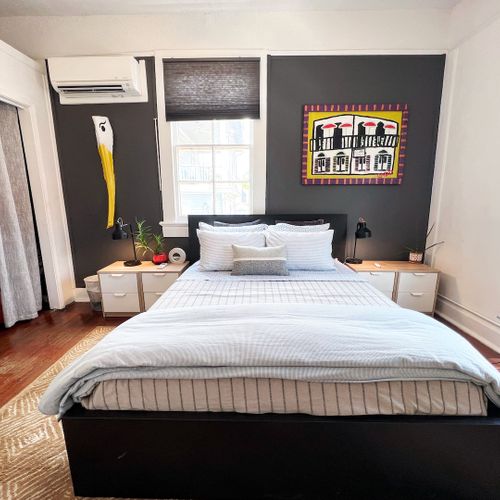 Main bedroom w/ a generous bed & vibrant wall art to set the mood.