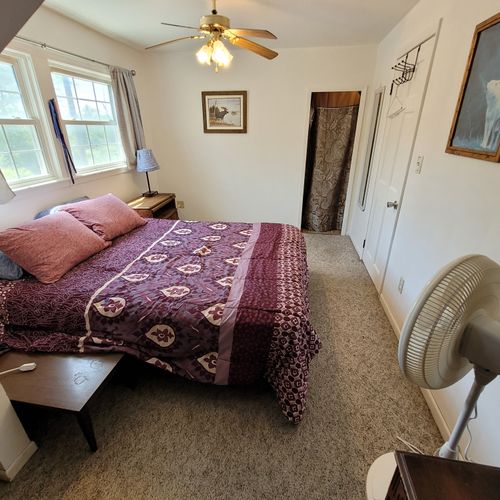 Bedroom #1 ( second floor):  large master bedroom with a queen-size bed, closet, vanity, ceiling fan, pedestal fan, and nightstand.