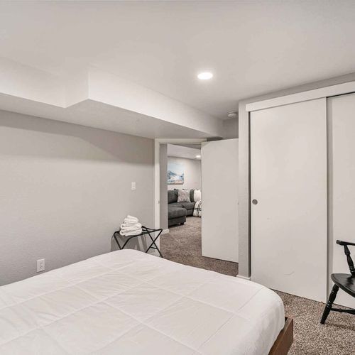 Downstairs offers two more bedrooms. This bedroom features a queen bed with soft linens and a comfortable mattress for a restful sleep.