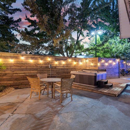 Unwind under the evening lights in our cozy outdoor seating area, complete with a private hot tub and a serene poolside view.