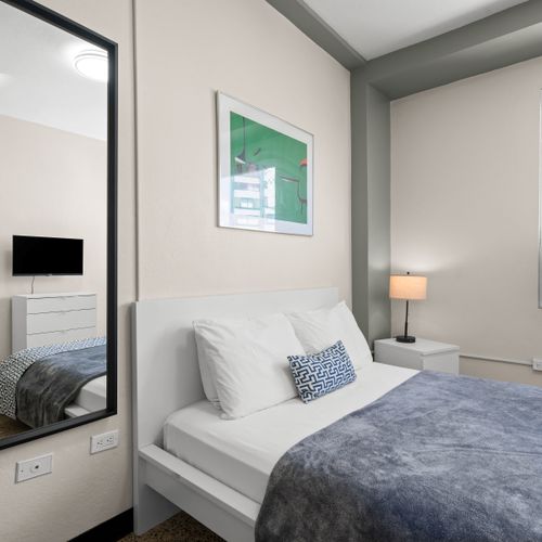 Drift into a peaceful slumber in our beautifully appointed bedroom featuring a plush queen-sized bed, crisp linens, and soft lighting for ultimate relaxation after a day of exploring.