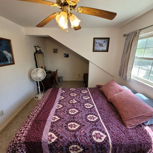 Bedroom #1 ( second floor):  large master bedroom with a queen-size bed, closet, vanity, ceiling fan, pedestal fan, and nightstand.
