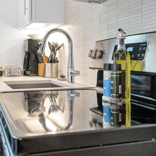 Well-stocked stove area w/ utensils, spices & cookware within easy reach.
