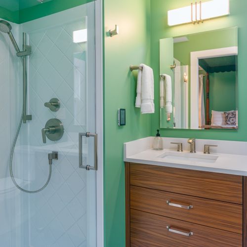 The Green Room ensuite bathroom has a walk-in shower, walnut vanity and top-line amenities and towels.