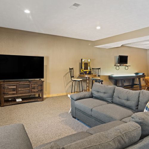 Lower level:  great family space in the lower level with dining table, wet bar, games, sofa, and television.