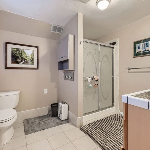 The upstairs hall bathroom is spacious with a stand-up shower and single vanity with drawers for extra storage.