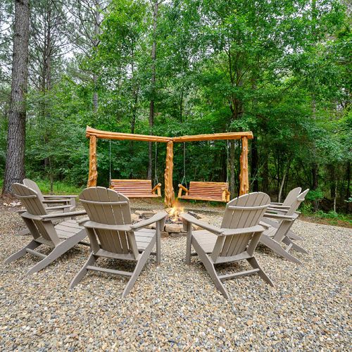Fire pit surrounded by Adirondack chairs.