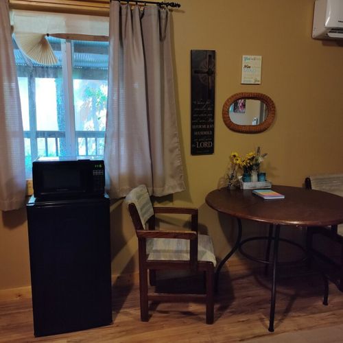 Main room:  features two double beds, small dining table with chairs, and a sink / kitchenette.