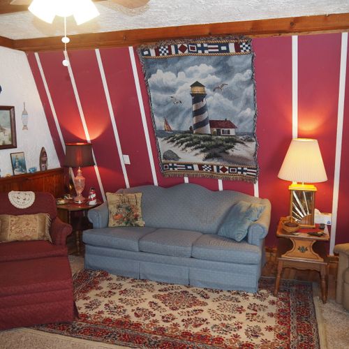 Living room:  includes a sofa, comfy chairs, live-streaming television, and entrance out to the deck.