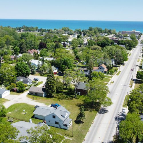 Exterior:  an aerial photo with the house in the foreground and downtown oscoda and lake huron in the background.