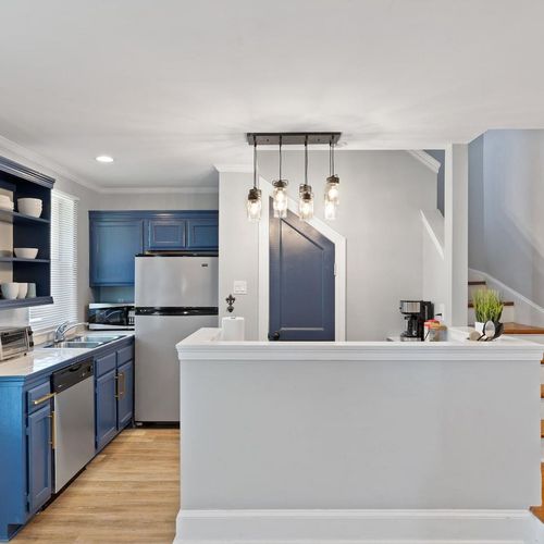 Stylish kitchen w/ navy cabinetry, pendant lights & plenty of counter space.